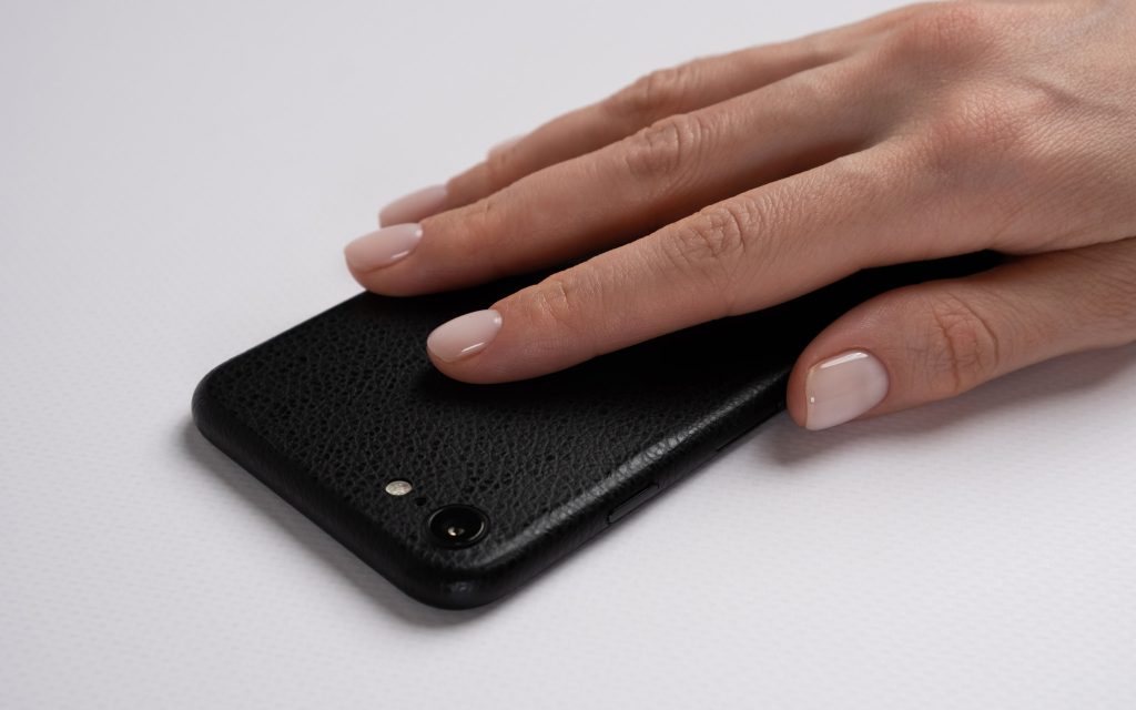 Скин черная кожа на iPhone SE 2022 на столе